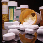 Drug Costs EXPLODE—Teachers and Cops Feel the Heat Assorted prescription pill bottles and tablets scattered.