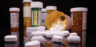Assorted prescription pill bottles and tablets scattered.