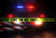 66 Counts Against ‘Reformed’ Killer – System FAILS? Police car behind yellow caution tape at night.