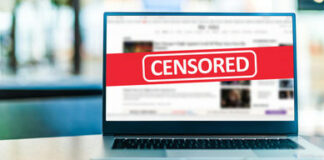 Laptop screen with CENSORED banner over webpage
