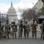 Armed soldiers standing guard outside the Capitol building