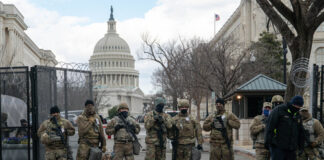 Armed soldiers standing guard outside the Capitol building