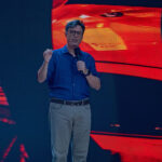 Late-Night Giant CRUMBLES: Colbert’s Show ENDS! Stephen Colbert speaking on stage with a vibrant backdrop