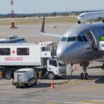 WATCH: Airport Sinkhole CHAOS – U.S. Flights Grounded! An airplane at an airport with an ambulance and ground crew nearby