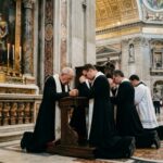 Anthropic’s Vatican ALLEGIANCE Ignites Moral Clash… Clergy members kneeling in prayer inside a grand cathedral