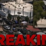 Aerial view of a large police presence at a scene marked as breaking news