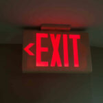 Air Chaos: EXIT DOOR Drama Deepens Red illuminated exit sign with left arrow.