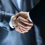 UNRECOGNIZED Ally — Massive LEVERAGE at Stake Two individuals in suits shaking hands firmly.