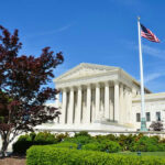 Supreme Court Quietly Rewires Voting Power Supreme Court building with American flag and trees.