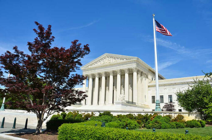 141389569 Supreme Court building with American flag and trees.