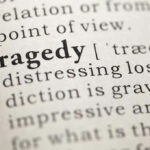 Close-up of the word Tragedy in a dictionary