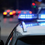 Multi-State Hunt Ends — Questions Explode Police car with flashing blue lights on street.