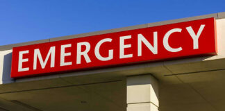 Red and white Emergency sign outside building.