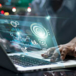 Person using laptop with futuristic data and analytics interface
