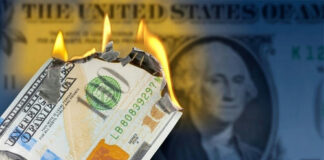 Burning US hundred-dollar bill with flames at the corner