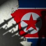 Silhouette of a soldier against a North Korean flag background