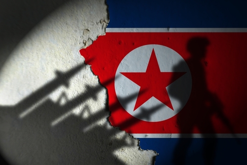 Shadows,Of,North,Korean,Missiles,And,Soldiers,On,The,Wall. Silhouette of a soldier against a North Korean flag background