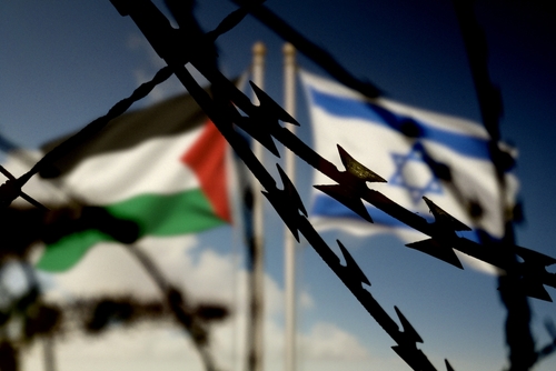 Flags,Of,Israel,And,Palestine,And,Barbed,Wire Barbed wire in the foreground with Palestinian and Israeli flags in the background
