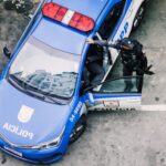 Police officer interacting with a police car in an urban environment