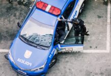 Police officer interacting with a police car in an urban environment