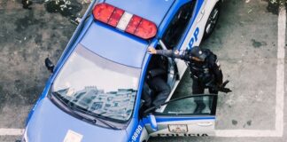 Police officer interacting with a police car in an urban environment