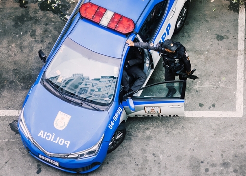 Police officer interacting with a police car in an urban environment