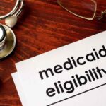 RIGGED Medicaid MEGA-DEAL Exposed Medicaid eligibility form with stethoscope and pen on desk