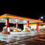 6 States Jack Gas PRICES By JULY 1 — Do You Live in One of THESE? A gas station illuminated at night with fuel pumps and a convenience store