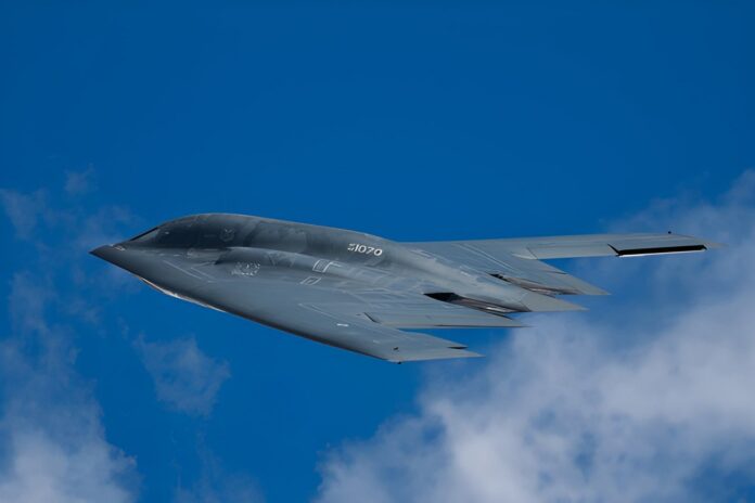 Stealth bomber flying against a clear blue sky