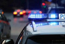 Find My MacBook Beat The System Police car with flashing blue lights on street.