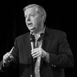 Man speaking into a microphone on stage