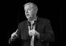 Man speaking into a microphone on stage