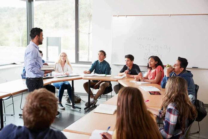 shutterstock_1127431418 Teacher speaking to students in a classroom discussion