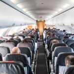 Trump-Era Clampdown Hits The Tarmac Airplane cabin with passengers seated in rows