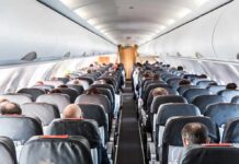 Trump-Era Clampdown Hits The Tarmac Airplane cabin with passengers seated in rows