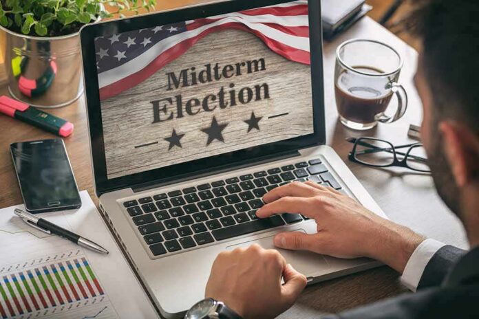 shutterstock_1180415776 Person using laptop displaying midterm election screen
