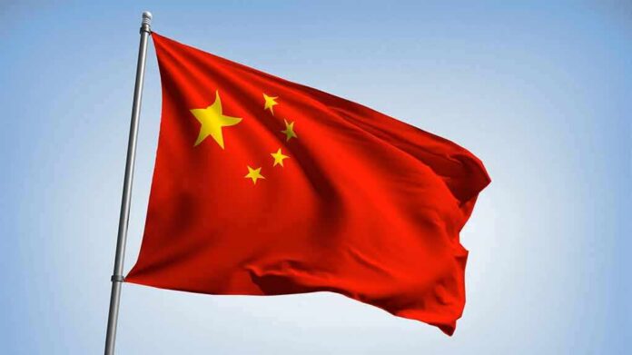 shutterstock_1360597382-1 Chinese national flag waving on a pole