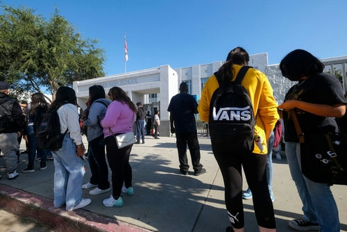 shutterstock_2190331639-1 Students standing outside a high school entrance