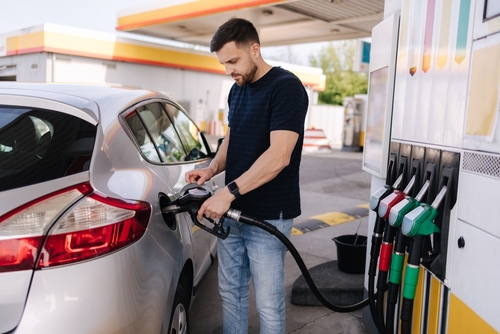 Handsome,Young,Man,Refueling,Car,At,Gas,Station.,Male,Filling Man fueling a silver car at a gas station
