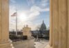 U.S. Capitol dome viewed between marble columns at sunset