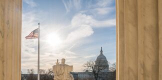 U.S. Capitol dome viewed between marble columns at sunset