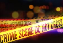 Open Borders, Brutal Consequences? Yellow police tape marking a crime scene with blurred lights in the background