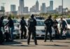 Police officers in tactical gear conducting an arrest in a parking lot