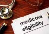 Medicaid eligibility form with stethoscope and pen on desk