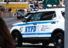 Manhattan Worship Turns Violent — Why? NYPD police car on a city street scene.