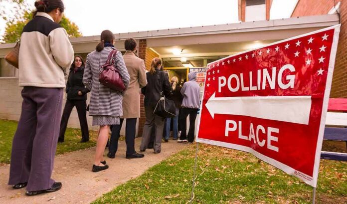 shutterstock_1047600649 People lining up outside a polling place