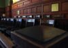 Lawmen Stunned — Quiet Release Sparks Fury Empty wooden jury box with numbered chairs