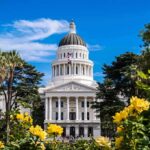 California’s Latest Tax Target Isn’t Just Cash Capitol building with white dome framed by trees and yellow flowers