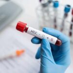 Lawmakers Target Decades-Old Public Health Restrictions Gloved hand holding a blood sample tube labeled for HIV test
