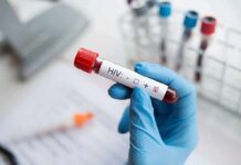 Lawmakers Target Decades-Old Public Health Restrictions Gloved hand holding a blood sample tube labeled for HIV test